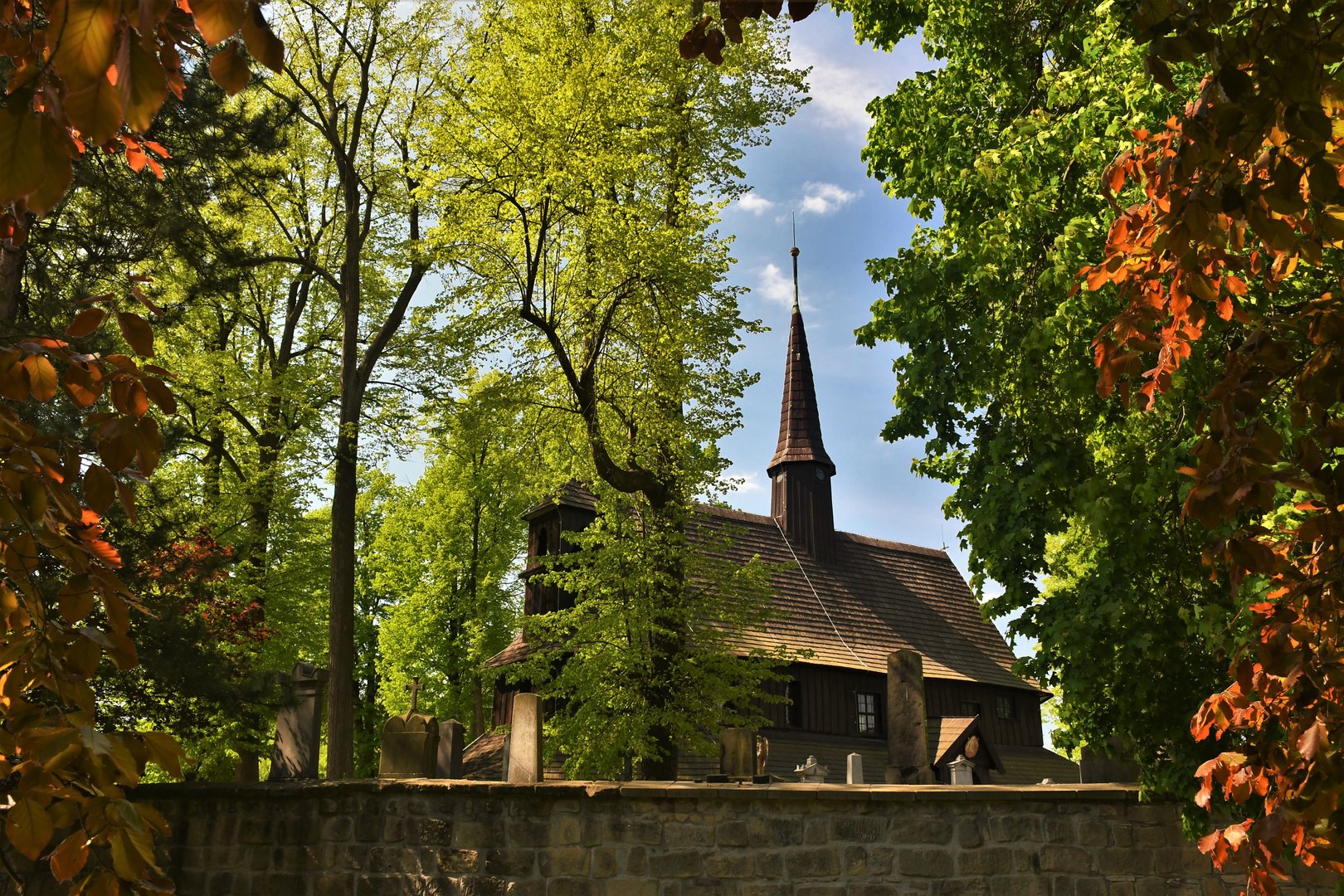 Pohled na krajinu v mlze, ze které vystupují vrcholky kopců